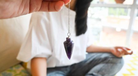 Alternative medicine therapist using pendulum to make a diagnosis. Health Checking, Spiritual New age esoteris holistic therapy. Cosmic energy vibrations.